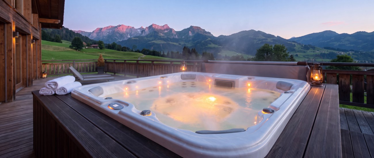 Spa sur une terrasse de chalet au coucher du soleil